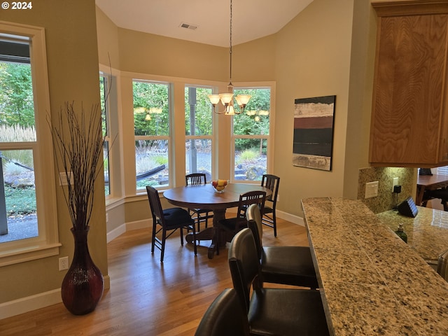899 NW Angel Heights Rd, Stevenson, WA 98648 - dining area with baseboards, light wood-type flooring, a chandelier, and vaulted ceiling