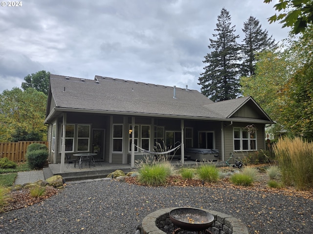 899 NW Angel Heights Rd, Stevenson, WA 98648 - rear view of house with an outdoor fire pit, a patio area, a shingled roof, and a hot tub