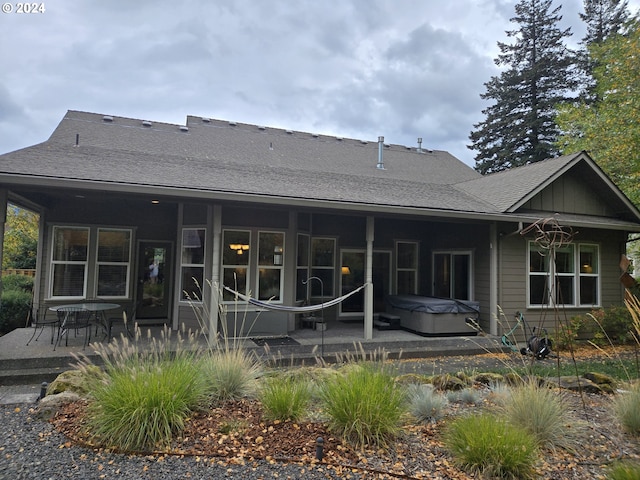 899 NW Angel Heights Rd, Stevenson, WA 98648 - rear view of house with a hot tub, a patio area, and roof with shingles