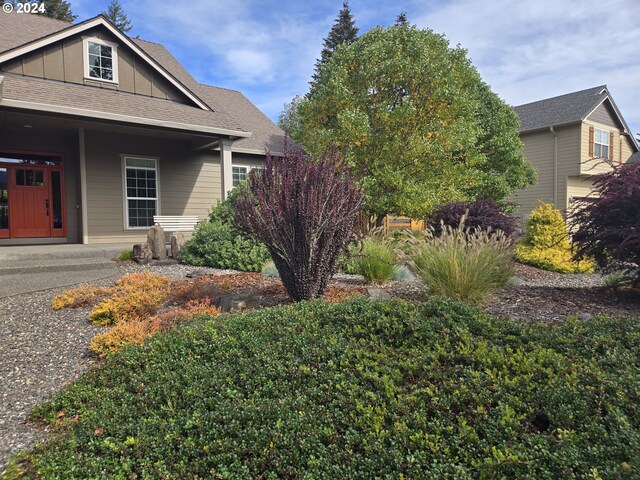 899 NW Angel Heights Rd, Stevenson, WA 98648 - view of side of home with board and batten siding, a shingled roof, and a porch