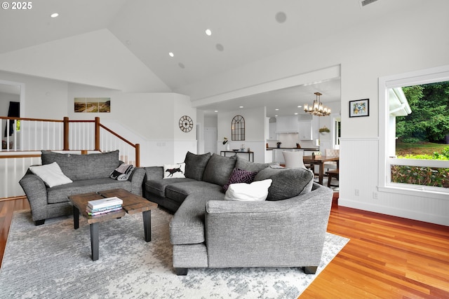 90955 Southview Ln, Florence, OR 97439 - living room featuring light wood-style flooring, a wainscoted wall, a chandelier, high vaulted ceiling, and recessed lighting