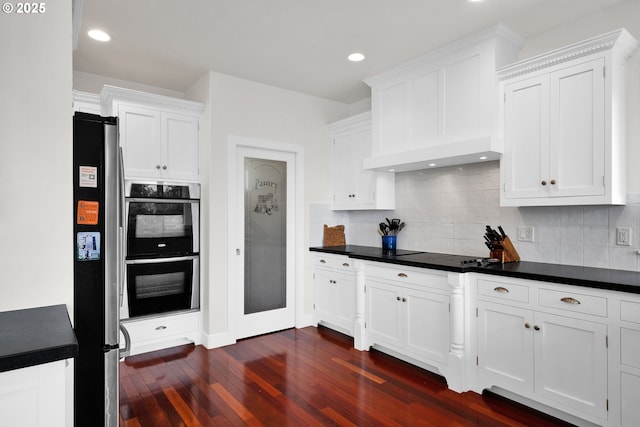 90955 Southview Ln, Florence, OR 97439 - kitchen with stainless steel appliances, white cabinetry, dark wood-style flooring, backsplash, and recessed lighting