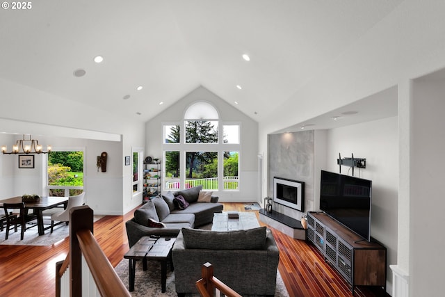 90955 Southview Ln, Florence, OR 97439 - living room with high vaulted ceiling, a chandelier, wood finished floors, a tile fireplace, and recessed lighting
