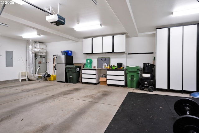 90955 Southview Ln, Florence, OR 97439 - garage featuring electric panel, a garage door opener, and freestanding refrigerator