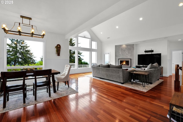 90955 Southview Ln, Florence, OR 97439 - living area featuring healthy amount of natural light, a chandelier, dark wood-style floors, lofted ceiling, and a high end fireplace