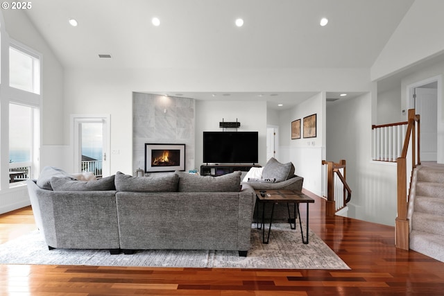 90955 Southview Ln, Florence, OR 97439 - living room featuring lofted ceiling, a fireplace, wood finished floors, stairway, and recessed lighting