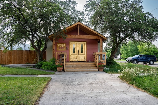 view of front of home with covered porch and fence