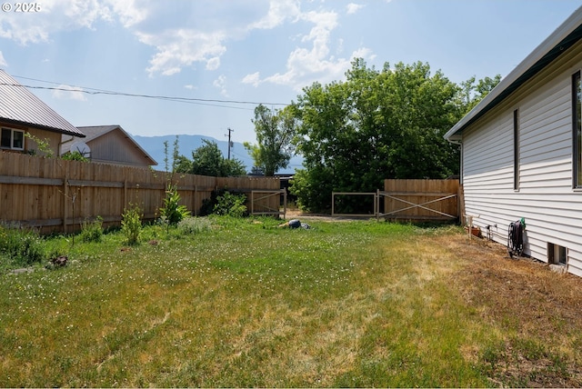 view of yard featuring a gate, fence, and a mountain view