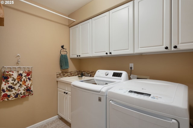 laundry area featuring cabinet space, washing machine and clothes dryer, and baseboards