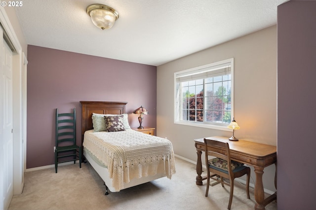 bedroom with light carpet, baseboards, and a closet