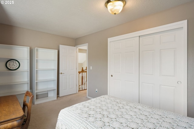 bedroom with light carpet, a closet, and a textured ceiling