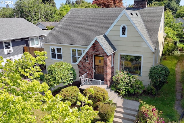 1830 N Winchell St, Portland, OR 97217 - tudor house featuring roof with shingles, a chimney, and brick siding
