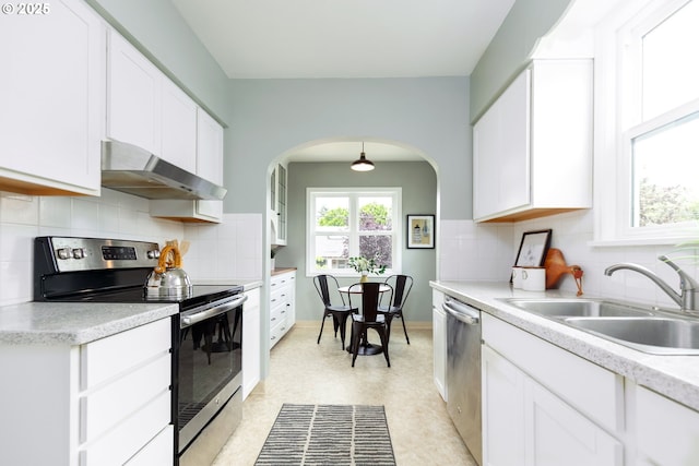 1830 N Winchell St, Portland, OR 97217 - kitchen with appliances with stainless steel finishes, ventilation hood, white cabinets, and arched walkways