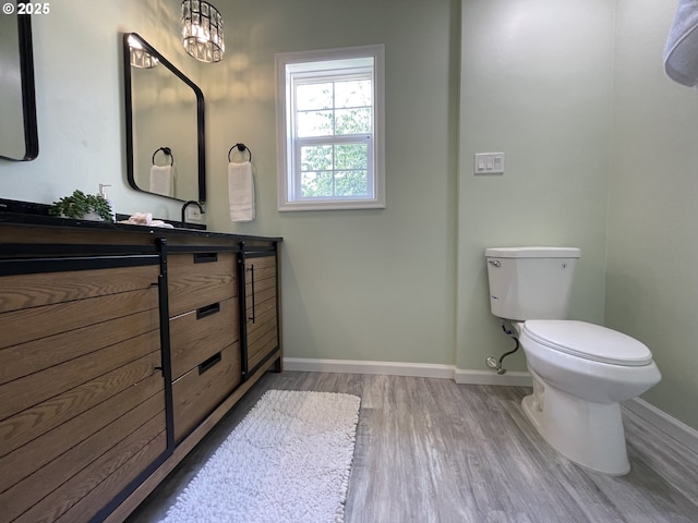 1830 N Winchell St, Portland, OR 97217 - bathroom featuring wood finished floors, toilet, baseboards, and vanity