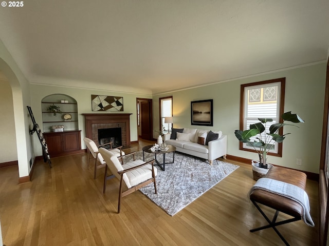 1830 N Winchell St, Portland, OR 97217 - living area with arched walkways, plenty of natural light, light wood-style floors, built in shelves, and ornamental molding