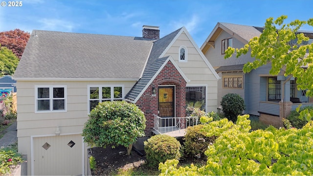 1830 N Winchell St, Portland, OR 97217 - english style home featuring a chimney, roof with shingles, and brick siding