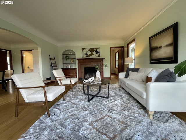 1830 N Winchell St, Portland, OR 97217 - living area with arched walkways, built in features, wood finished floors, and a fireplace