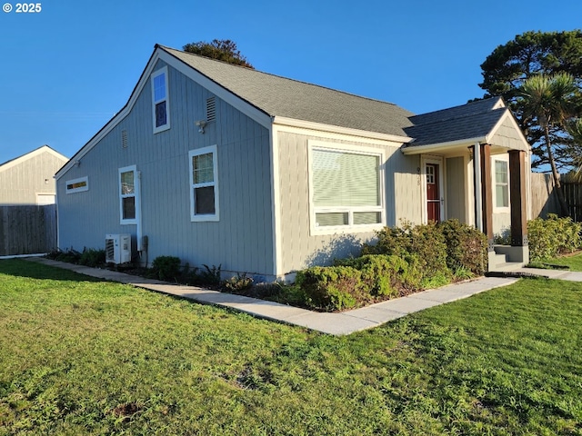 view of side of property with central AC, a lawn, and fence