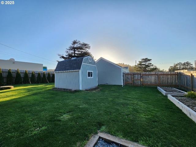 view of yard featuring a storage shed, an outbuilding, a fenced backyard, and a garden