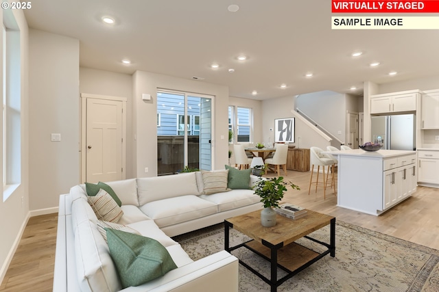 living room featuring recessed lighting, stairway, baseboards, and light wood finished floors