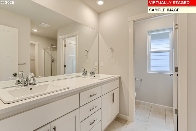 bathroom with a sink, baseboards, a stall shower, and tile patterned floors