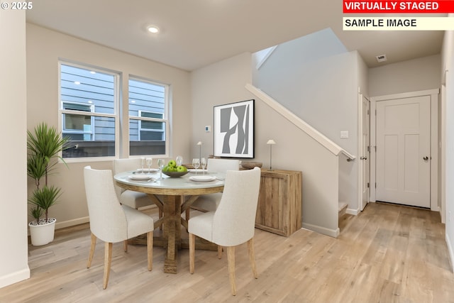 dining space with visible vents, baseboards, and light wood-style floors