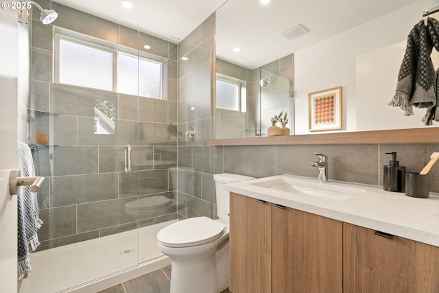 full bathroom with visible vents, toilet, a stall shower, decorative backsplash, and vanity