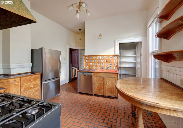 kitchen with vaulted ceiling, an inviting chandelier, and stainless steel appliances