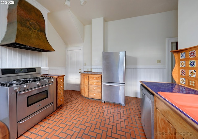 kitchen with sink, appliances with stainless steel finishes, and custom range hood