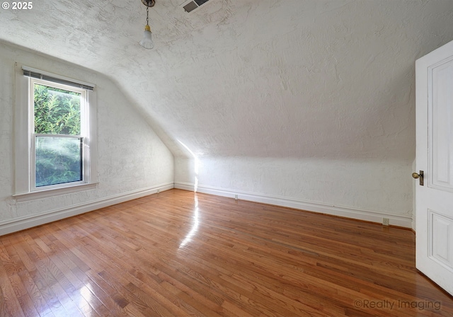 bonus room featuring vaulted ceiling and hardwood / wood-style flooring