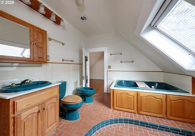 bathroom with toilet, tile patterned flooring, plenty of natural light, and vaulted ceiling with skylight