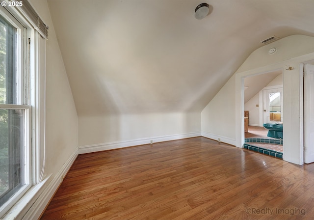 bonus room with vaulted ceiling and hardwood / wood-style flooring