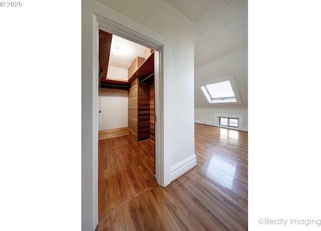 bonus room featuring a skylight and hardwood / wood-style floors