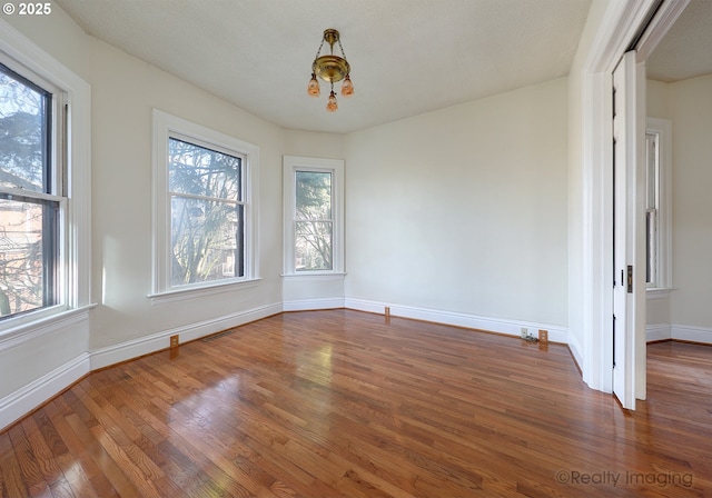 unfurnished dining area featuring wood-type flooring and a notable chandelier