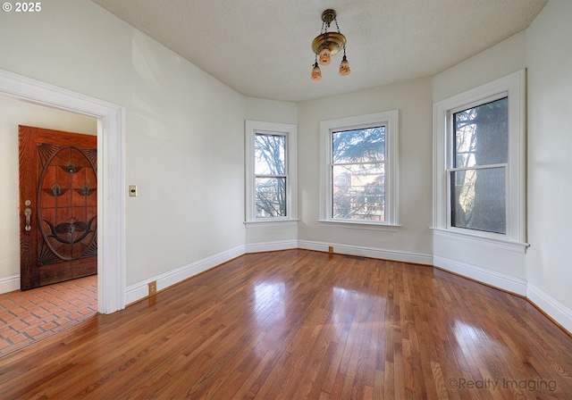 unfurnished dining area with a textured ceiling and hardwood / wood-style flooring