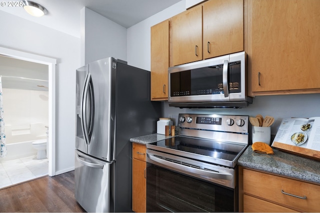 kitchen with dark hardwood / wood-style flooring and appliances with stainless steel finishes