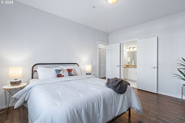 bedroom featuring ensuite bath and dark hardwood / wood-style floors