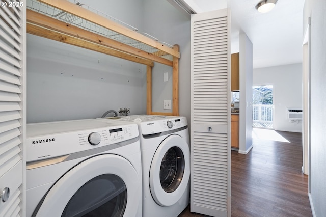 laundry area with dark wood-type flooring, washing machine and clothes dryer, and a wall mounted air conditioner