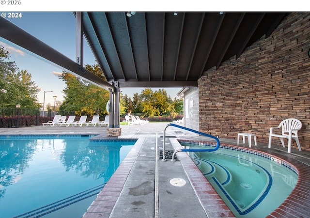 view of swimming pool featuring an in ground hot tub and a patio