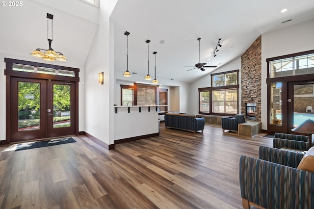 entryway featuring french doors, wood-type flooring, a fireplace, and high vaulted ceiling