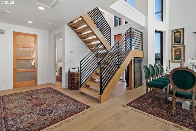 staircase featuring baseboards, recessed lighting, wood finished floors, and visible vents