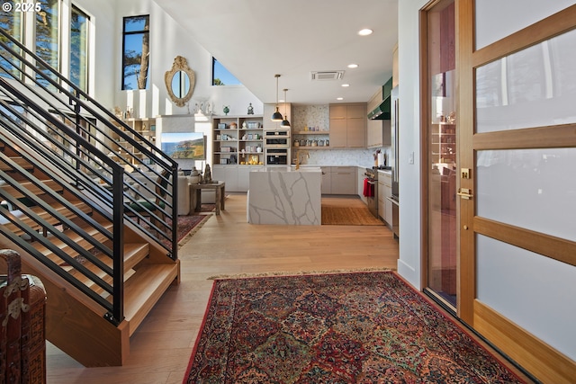 entryway with light wood-style floors, stairway, recessed lighting, and visible vents