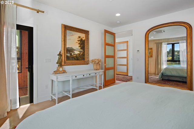 bedroom featuring visible vents, wood finished floors, baseboards, recessed lighting, and arched walkways