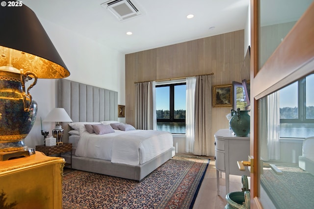 bedroom featuring visible vents, recessed lighting, light tile patterned floors, and wooden walls