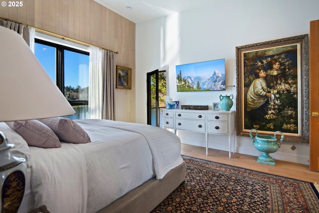 bedroom featuring wooden walls and wood finished floors