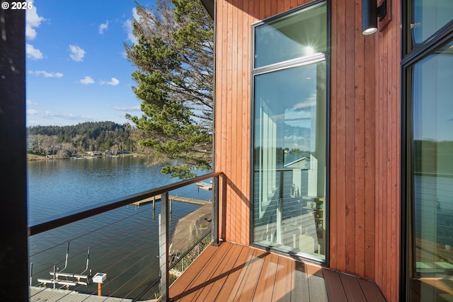 balcony featuring a water view and a view of trees