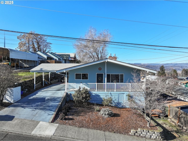 view of front of house featuring an attached carport, a porch, and concrete driveway