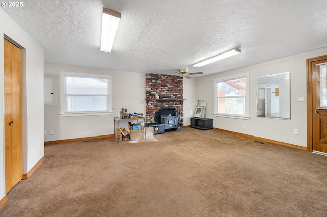 4616 SE 128th Ave, Portland, OR 97236 - unfurnished living room with a wood stove, a textured ceiling, carpet floors, and ceiling fan