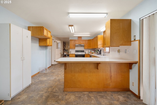 4616 SE 128th Ave, Portland, OR 97236 - kitchen with electric range oven, under cabinet range hood, stone finish flooring, and a peninsula