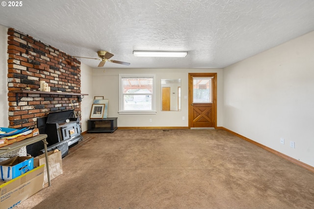 4616 SE 128th Ave, Portland, OR 97236 - unfurnished living room featuring a wood stove, a textured ceiling, ceiling fan, and carpet flooring